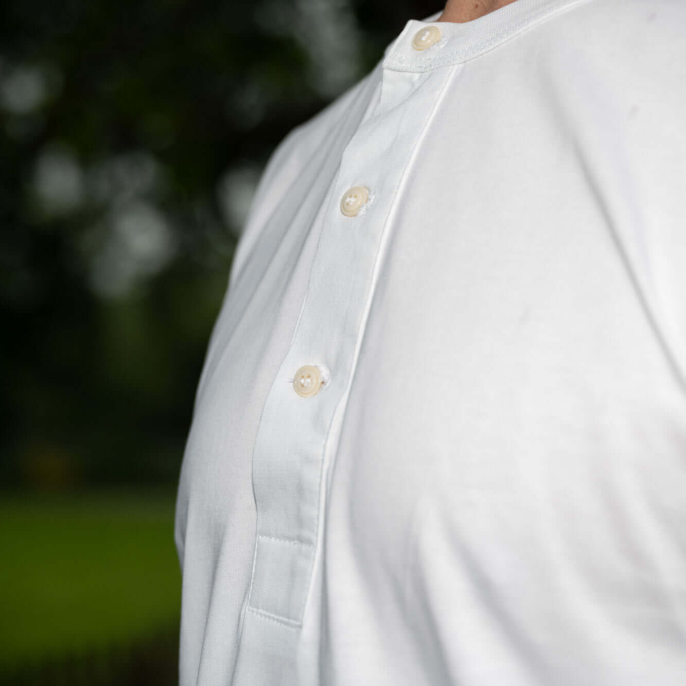 Chest close up of three button placket on a white Life Scholar Henley T-Shirt.